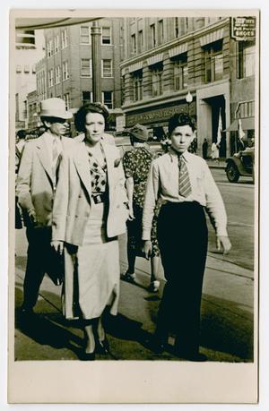 Primary view of object titled '[Photograph of Family Walking Down Sidewalk]'.
