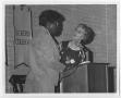 Primary view of [Barbara Jordan and an Unidentified Woman Standing at a Microphone]