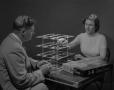 Primary view of [Man and Woman Playing with a 3-D Game Board]