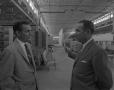Photograph: [Two Men In Austin Industries Warehouse]