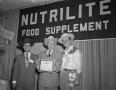 Primary view of [Three Men at the Nutrilite Food Supplement Convention]