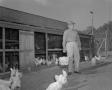 Photograph: [Man Holding Basket of Eggs with Chickens]