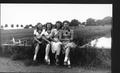 Photograph: [Four young women sitting on the cement ledge of the bridge over Dry …