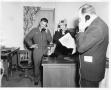 Photograph: [Two Men and a Woman Talking on Telephones]