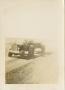 Photograph: [Man Driving Tractor and Towing Trailer]