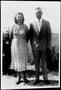 Photograph: [Mr. And Mrs. Linke standing in front of shrubs and tall grass]