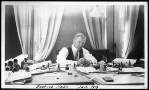Primary view of object titled '[A man working at a desk]'.
