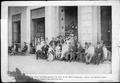 Photograph: [Men and boys sitting and standing near the "Gran Hotel"]