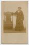 Primary view of [Postcard of an African-American Woman Standing Next to a Chair]