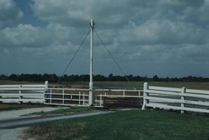 Primary view of object titled '[King Ranch NHL- Santa Gertrudis Div Headquarters, (view of facing WNW of Post-1947 Bump Gate Built by Humble Oil)]'.